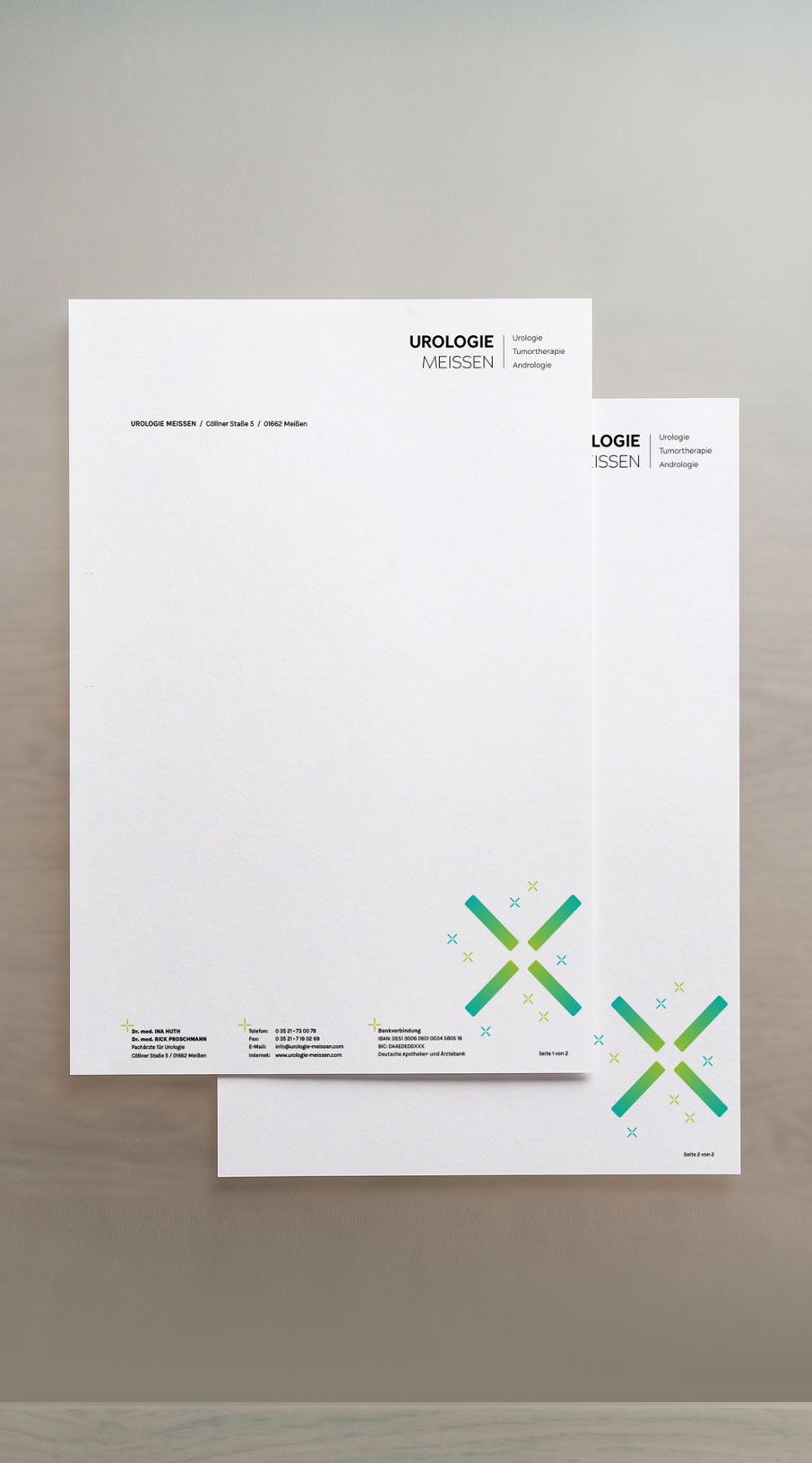 Zwei Briefbögen der Urologie Meissen mit dem grün-blauen Logo-Symbol, leicht versetzt übereinandergelegt.