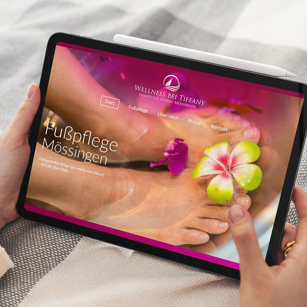 Auf einem Tablet: magentafarbene Bühne mit „Fußpflege Mössingen“ über dem Foto eines Fußbads mit Blüten.